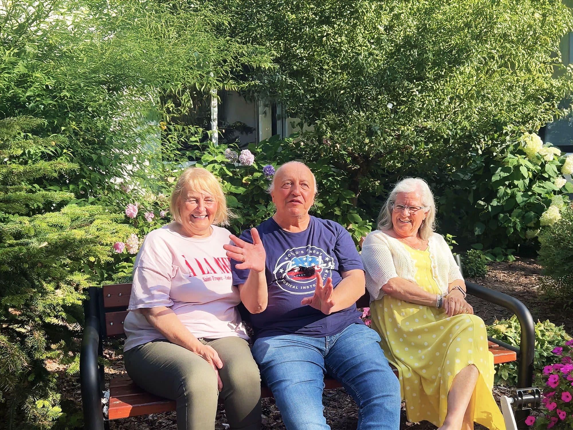 Ola, Sławek i Ania na ławce w Zdrowotelu wśród kwiatów